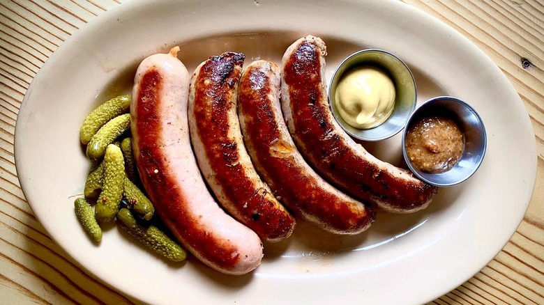 A plate of sausages with pickles and mustard at Suppenküche