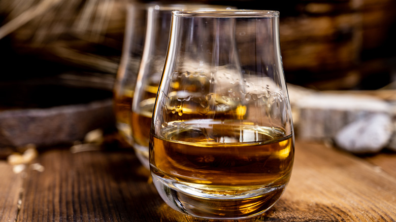 A row of scotch whiskies lined up on a wooden surface