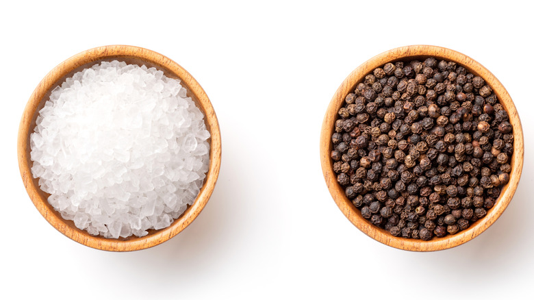 small wooden bowls of salt and peppercorns