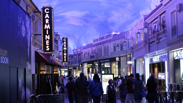 signs for Carmine's Italian Restaurant as a crowd of people walk through the Caesar's Forum