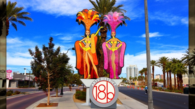 the 18b sign of Las Vegas' Arts District at an intersection with two colorful painted showgirls above