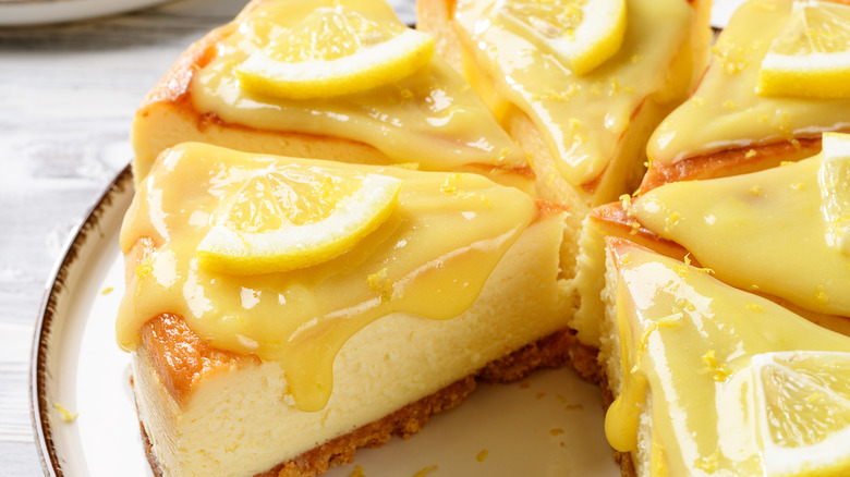 Lemon cheesecake sliced and topped with curd and fresh citrus