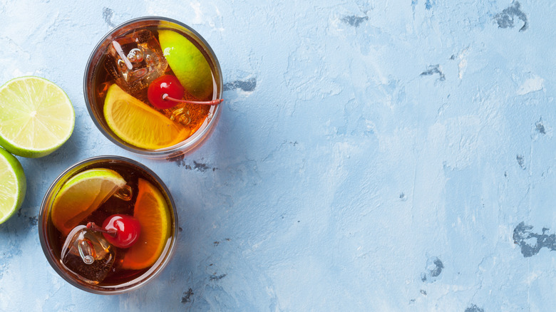 Overhead view of cherry coke margaritas with limes and cherries