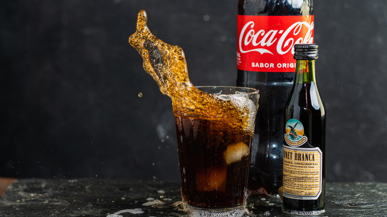A fernet and Coke with bottles of each ingredient