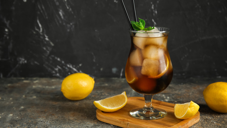 Cola cocktail with lemons and a fresh mint sprig garnish