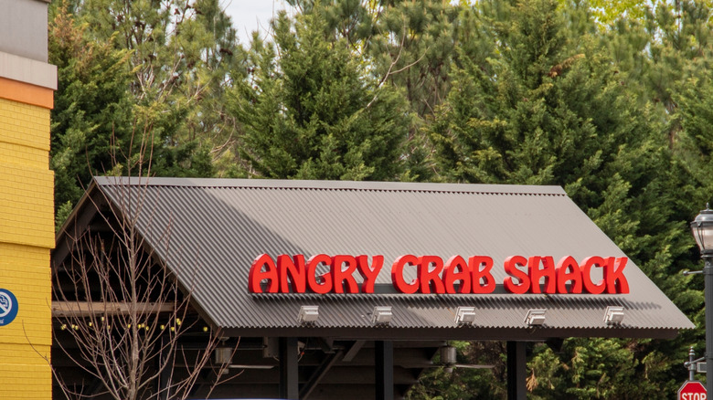 The exterior of an Angry Crab Shack with trees in the background