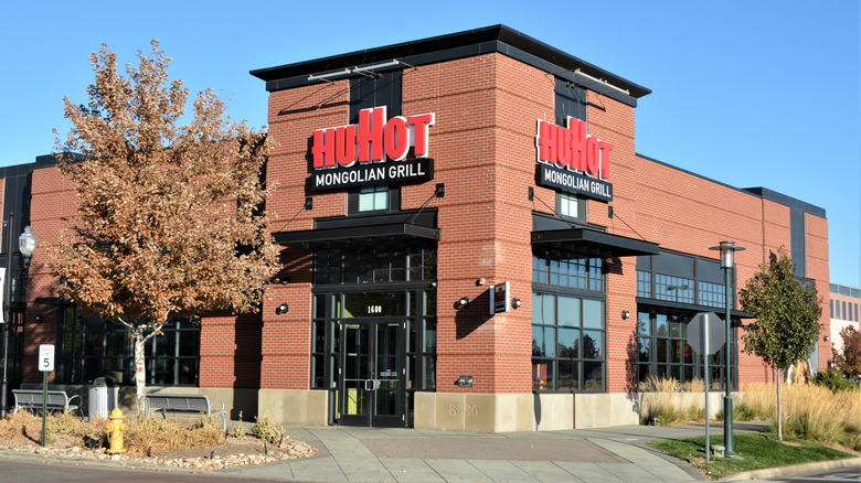 The exterior of HuHot Mongolian Grill restaurant with blue sky in the background