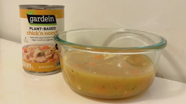 A can of Gardein Plant-Based Chick'n Noodl' next to a bowl of prepared soup