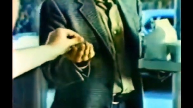 Still from commercial showing a woman's hand giving change back to a man holding a McDonald's order
