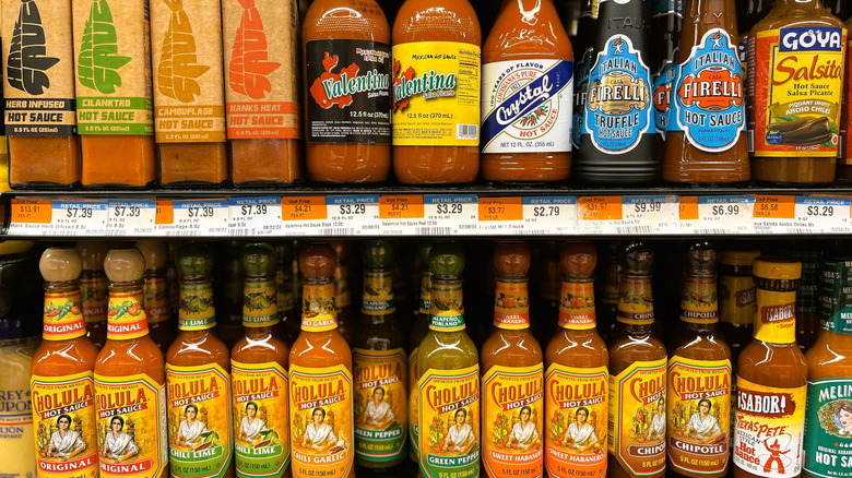 Various types of hot sauce on display in a grocery store
