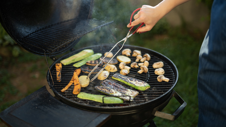 Person grilling vegetables outdoors