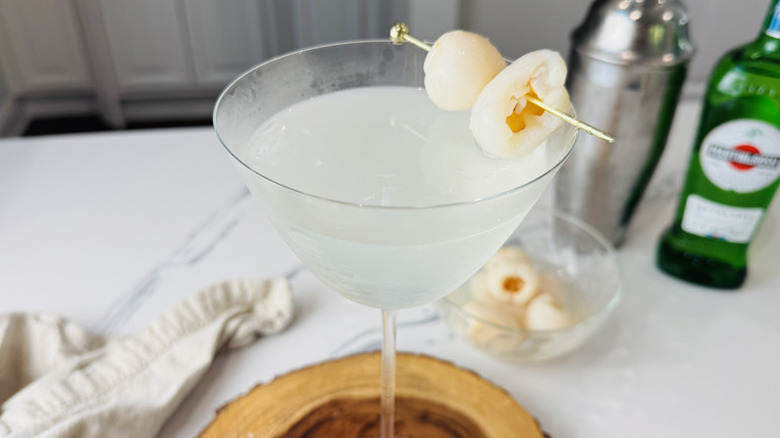 up-close shot of a lychee martini with liquor bottles in background