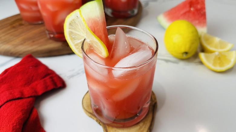 glass of watermelon lemonade with other drinks in the background