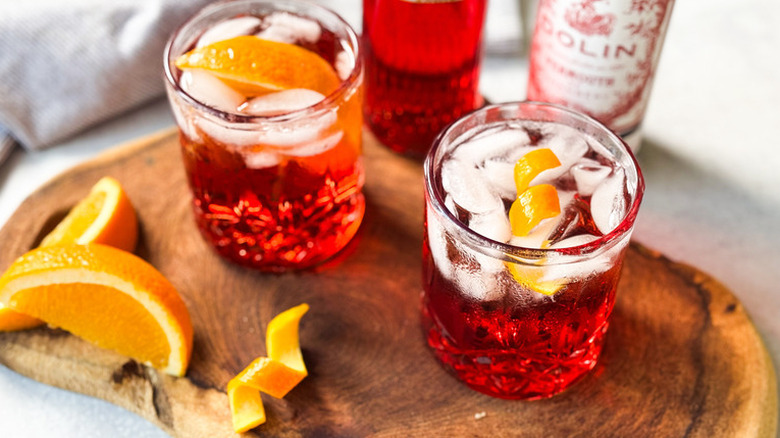 two Americanos with orange slices on wooden cutting