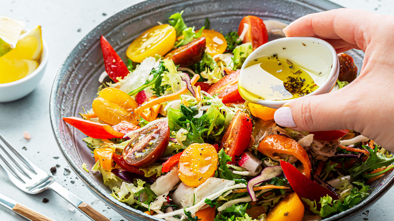 Bowl of lettuce with cup of dressing