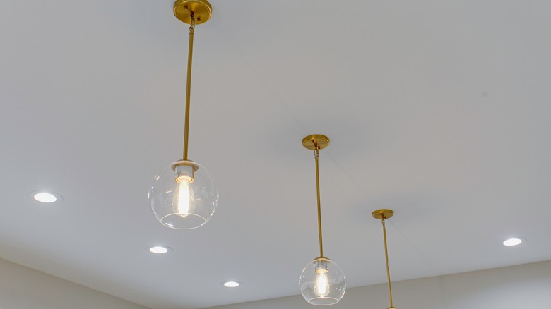 Globe lighting hanging from ceiling with brass fixtures