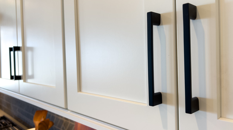 Chunky black handles on white cabinets