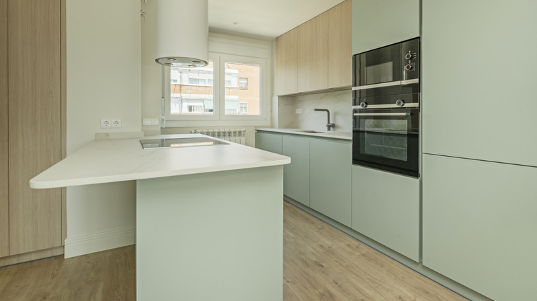 Slab front cabinets in soft pastels and light wood