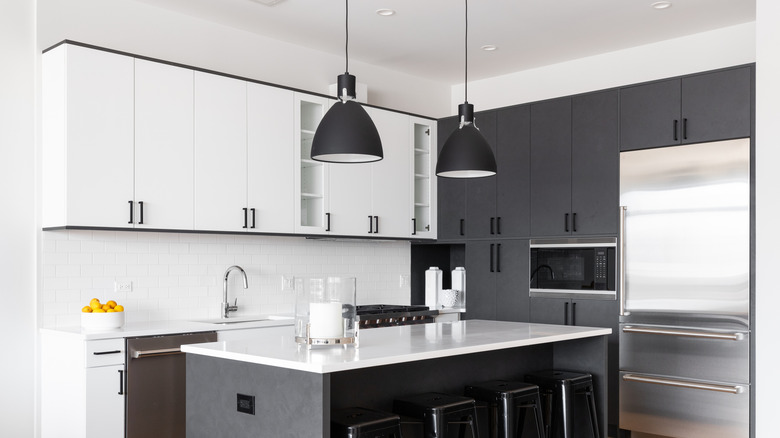 Black pendant lights in black and white kitchen