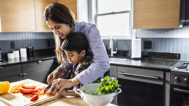 mother and son working together in kitchen