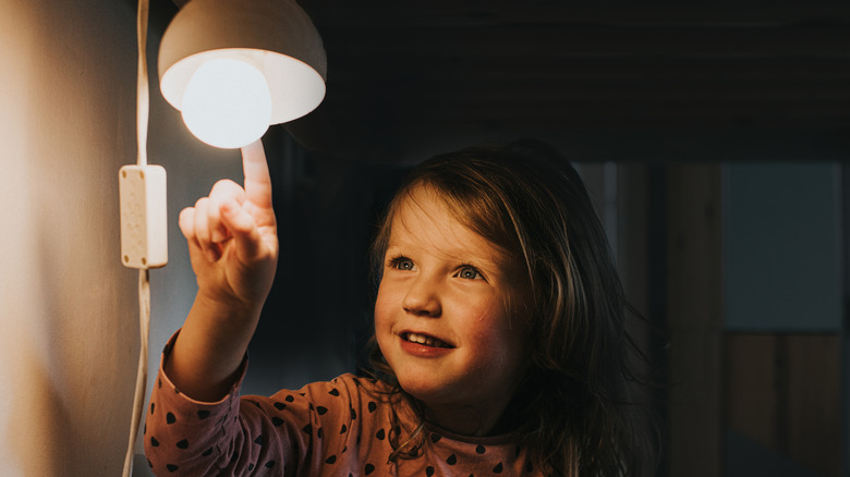 little girl poking at night light