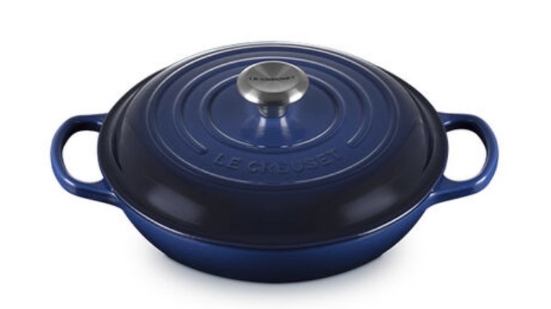 An indigo colored braiser with handles on both sides