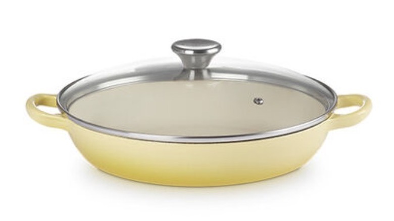 A yellow pot with handles on both sides and a glass lid