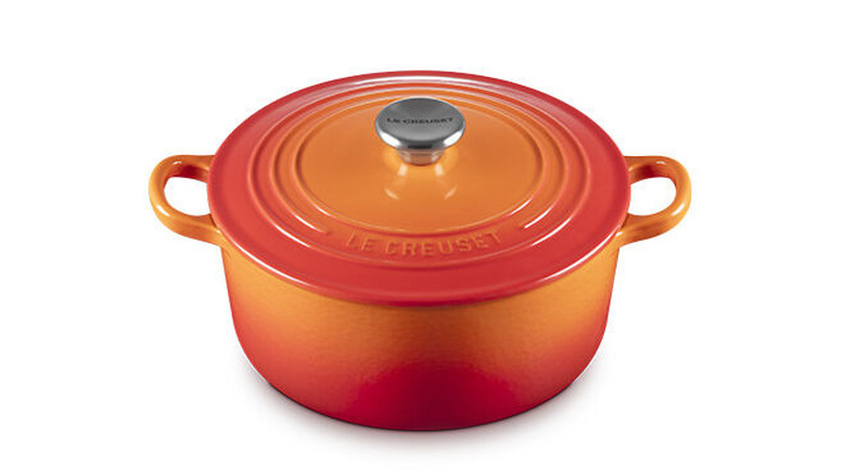 A lidded orange Le Creuset Dutch oven against a white background