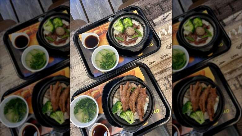A selection of dishes, including chicken feet, on black plastic trays at Grand Cafe