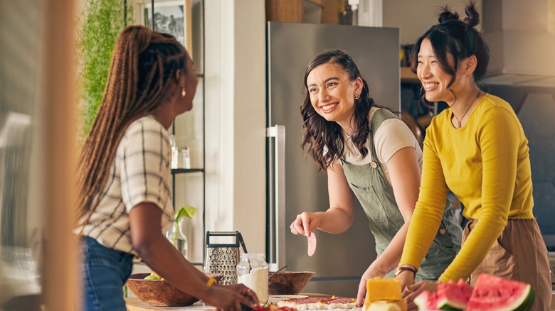 friends cooking together in kitchen