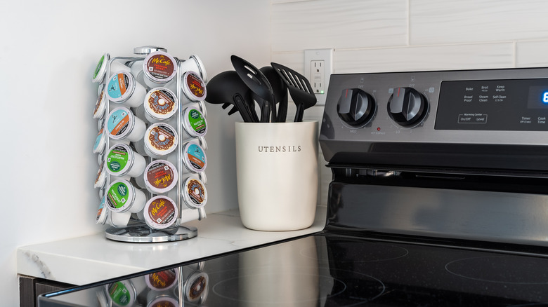 K-Cup organizer on a counter next to stove and utensils