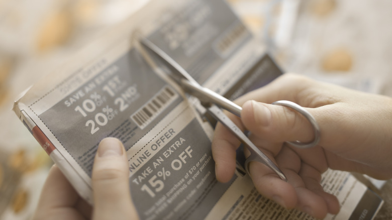 Person clipping paper coupons
