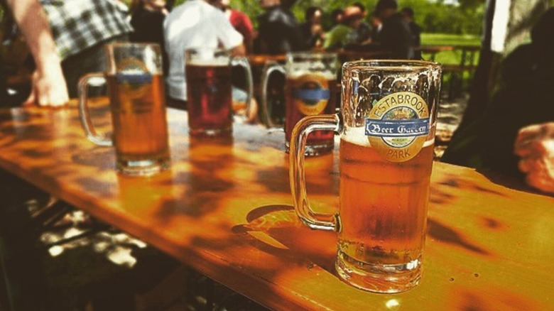 Beers on a table with an outdoor beer garden in the background