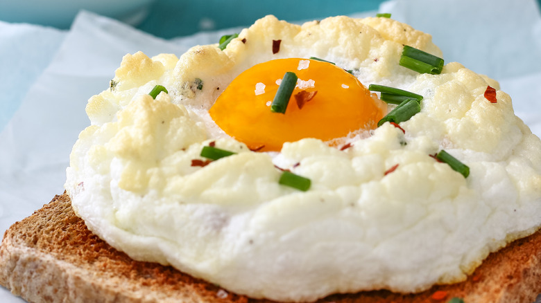 Cloud eggs sitting on toast and topped with green onions