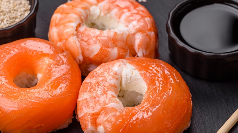 Sushi donuts on a plate with a small bowl of sauce next to them