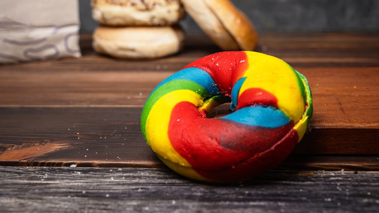 a rainbow donut on a wooden table top