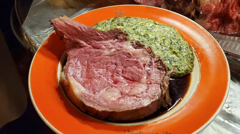A slice of prime rib with creamed spinach on a plate at House of Prime Rib