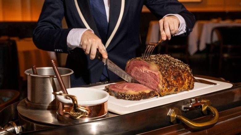 A server carving a prime rib at La Tête d'Or by Daniel