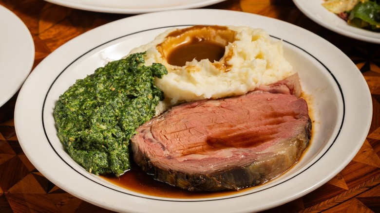 A plate of prime rib, creamed spinach, and mashed potatoes with gravy at Lawry's The Prime Rib