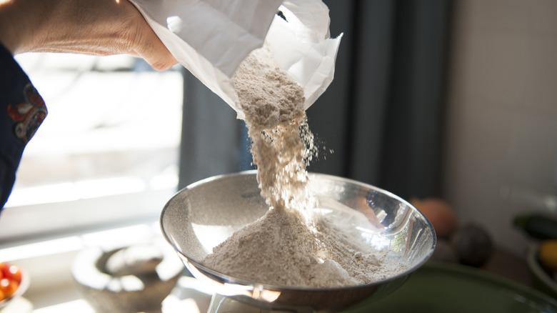 Pouring flour onto scale for measuring
