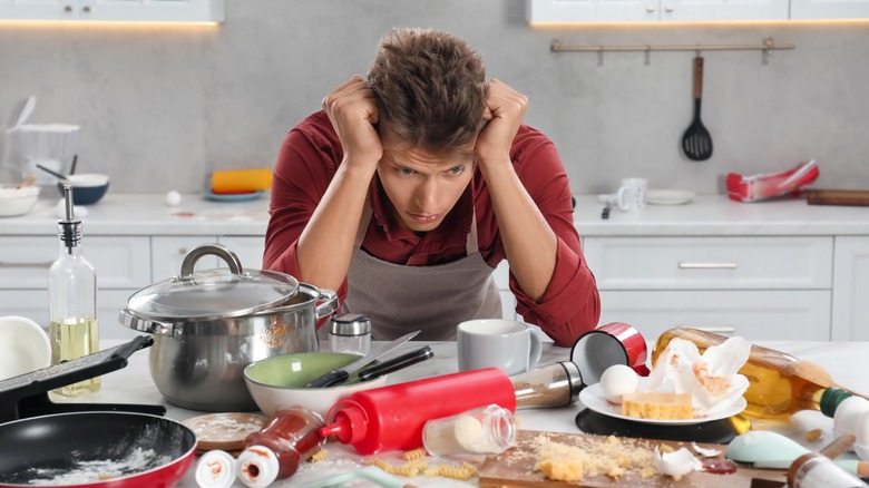 Upset person in kitchen with messy table