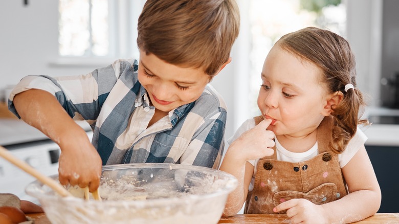 Kids baking and tasting batter