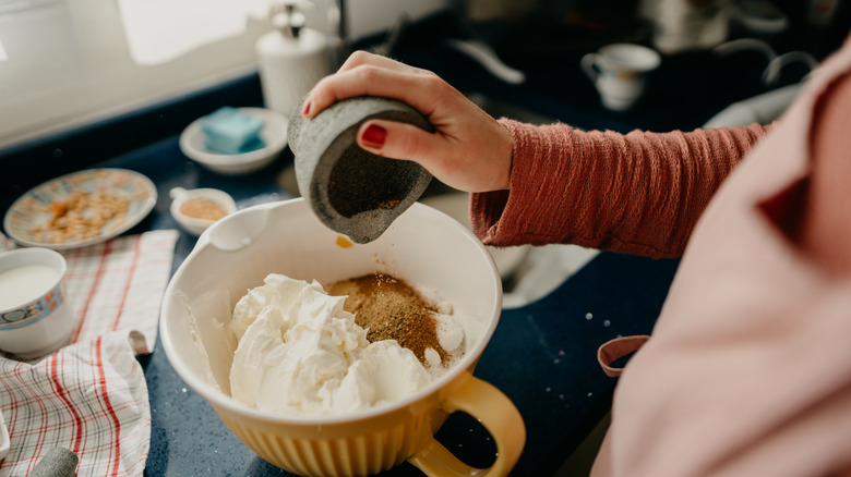 Person pouring different ingredients into a bowl