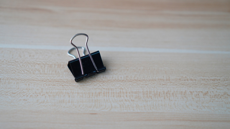 Single binder clip on wooden table