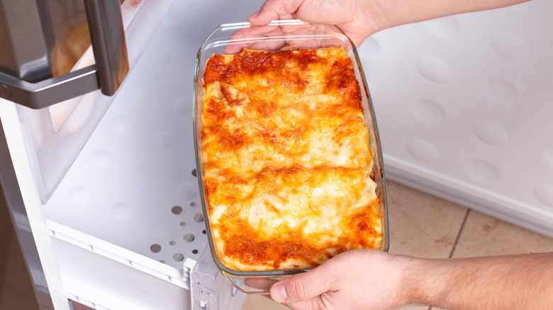 Person placing a prepared casserole in the refrigerator