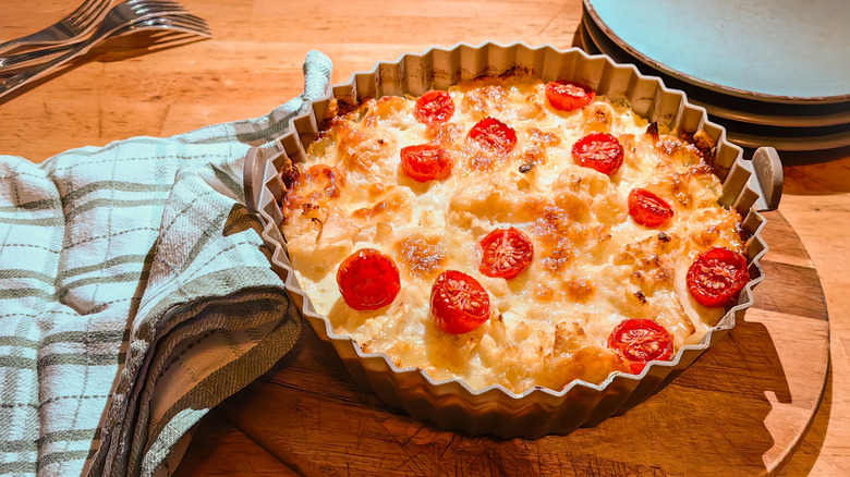 Round casserole dish resting on a wooden board waiting to be served