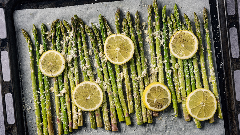Roasted asparagus on a baking sheet lined with parchment paper