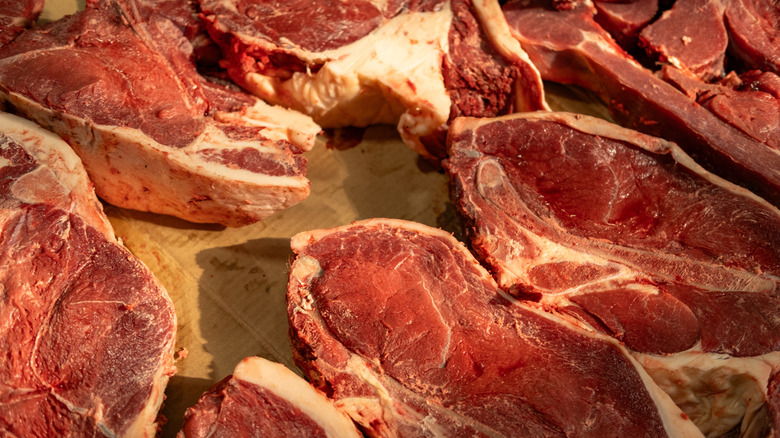 variety of steaks on a cardboard background