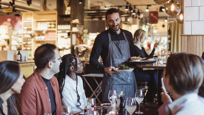 server talking to people at nice restaurant