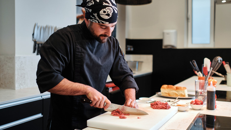 chef chopping steak in a kitchen